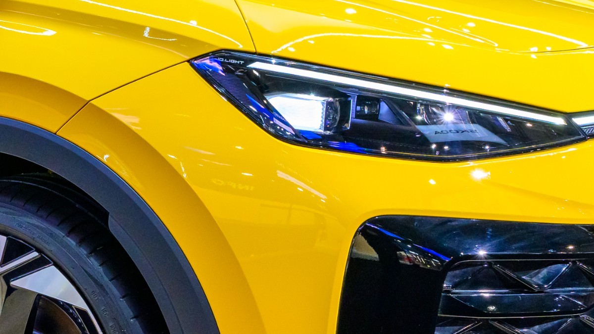 Imaginea prezintă de aproape farul cu LED-uri și o parte din grila frontală ale unui automobil de culoare galben strălucitor.