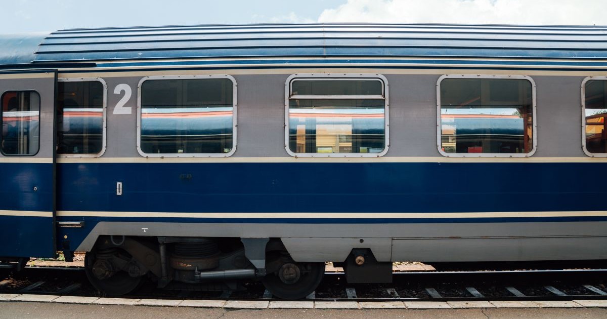 Un tren aflat pe șine în gara Brașov, România, se văd geamurile garniturii