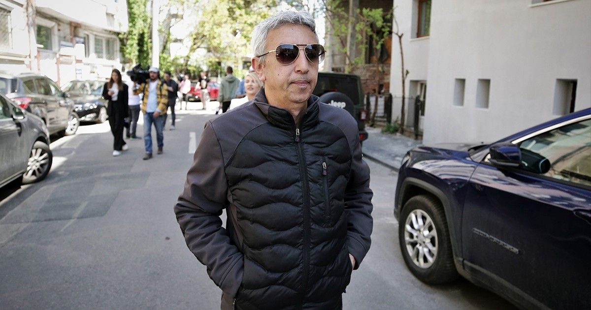 Un barbat in geaca neagra merge pe strada