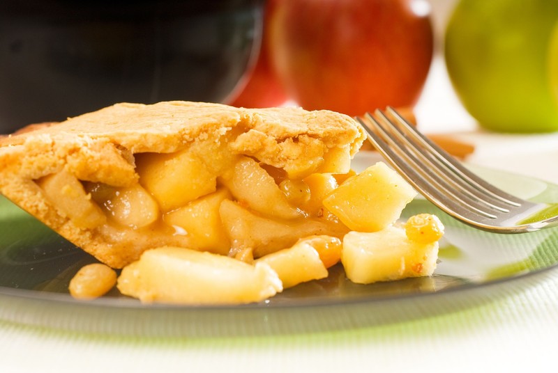 10242826 - fresh homemade apple pie over green glass dish macro colseup eating with fork
