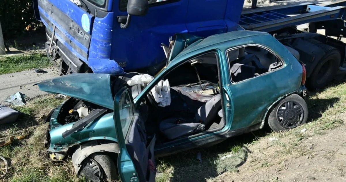Opel Corsa, de culoare verde închis, strivit de un TIR cu cabina de culoare albastră
