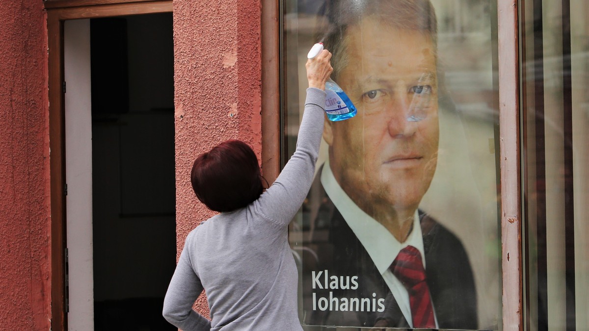 Femeie curăță poza lui Klaus Iohannis