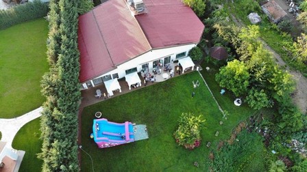 Imaginea cu drona care arată curtea aproape goală, singurii invitați de afară fiind cei câțiva de la mesele lipite de clădirea plină de oameni