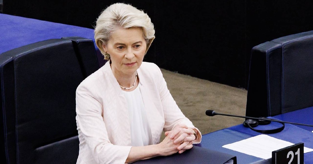 Ursula von der Leyen stă la un birou, e îmbrăcată în alb și pare că se gândește la o problemă complicată