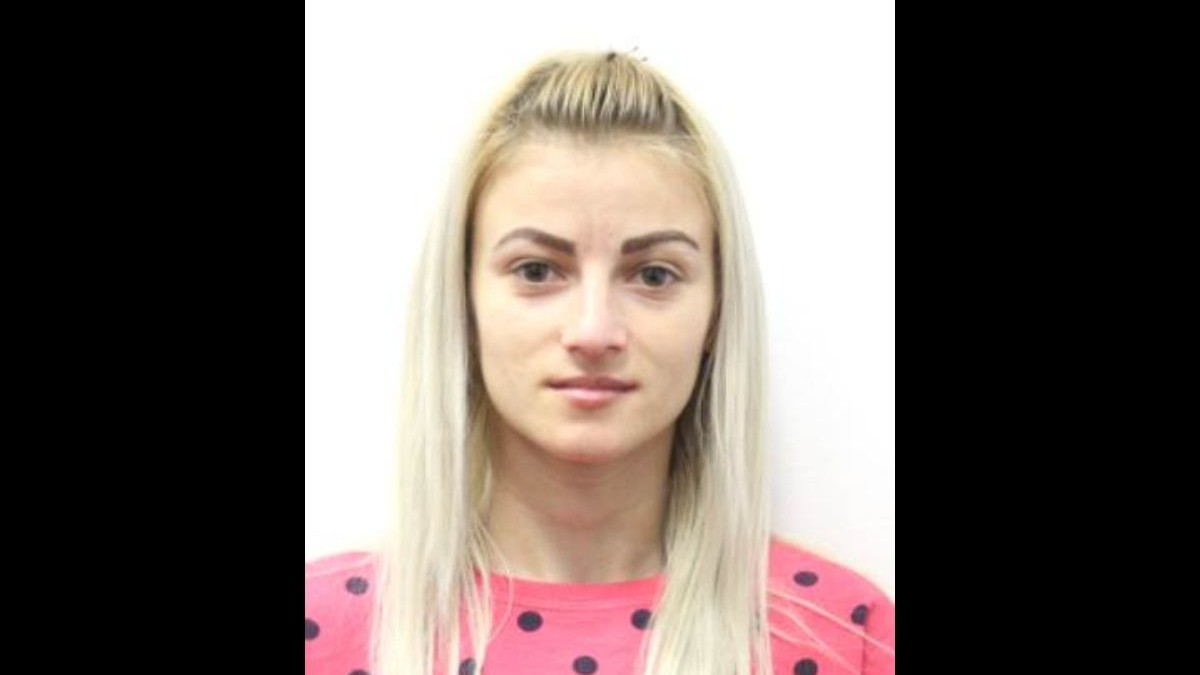 tânără cu părul blond, îmbrăcată într-o bluză roz cu buline negre