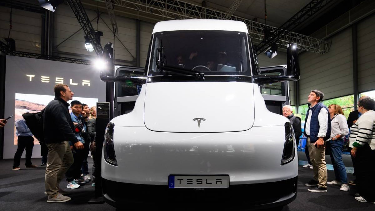Camionul electric Tesla Semi expus într-un salon auto. În jurul camionului sunt numeroși vizitatori, care îl privesc cu interes.