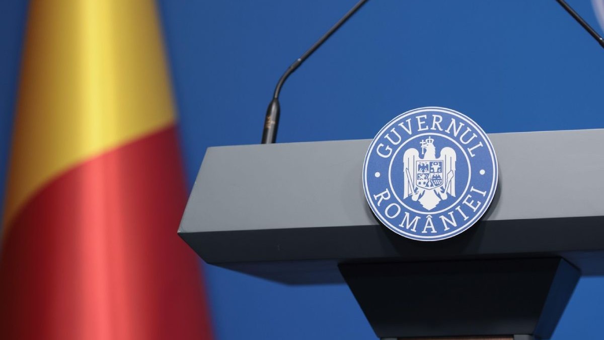 Pupitrul de la Guvernul României, cu sigla si steag in spate