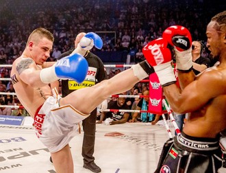 Amansio Paraschiv (stânga) îşi loveşte adversarul cu piciorul în timpul unui meci dintr-o gală Superkombat.
