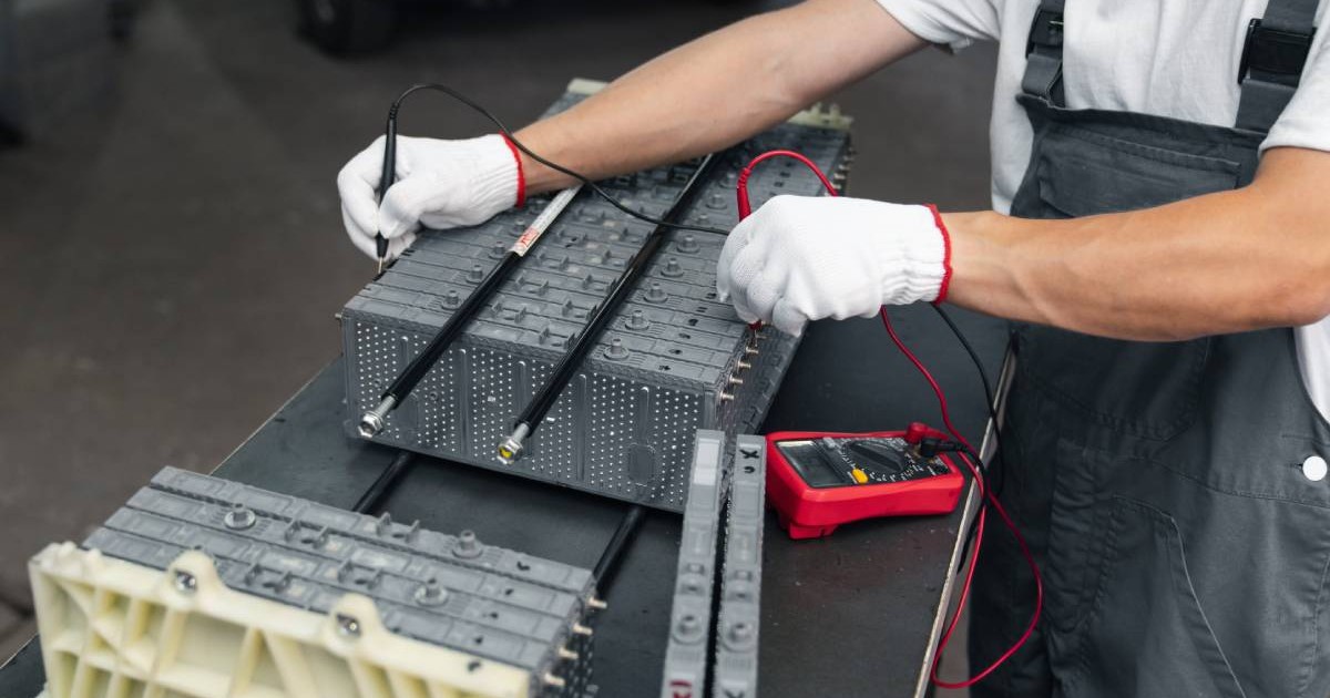 Mecanic verifica acumulatorul electric al mașinii hibrid