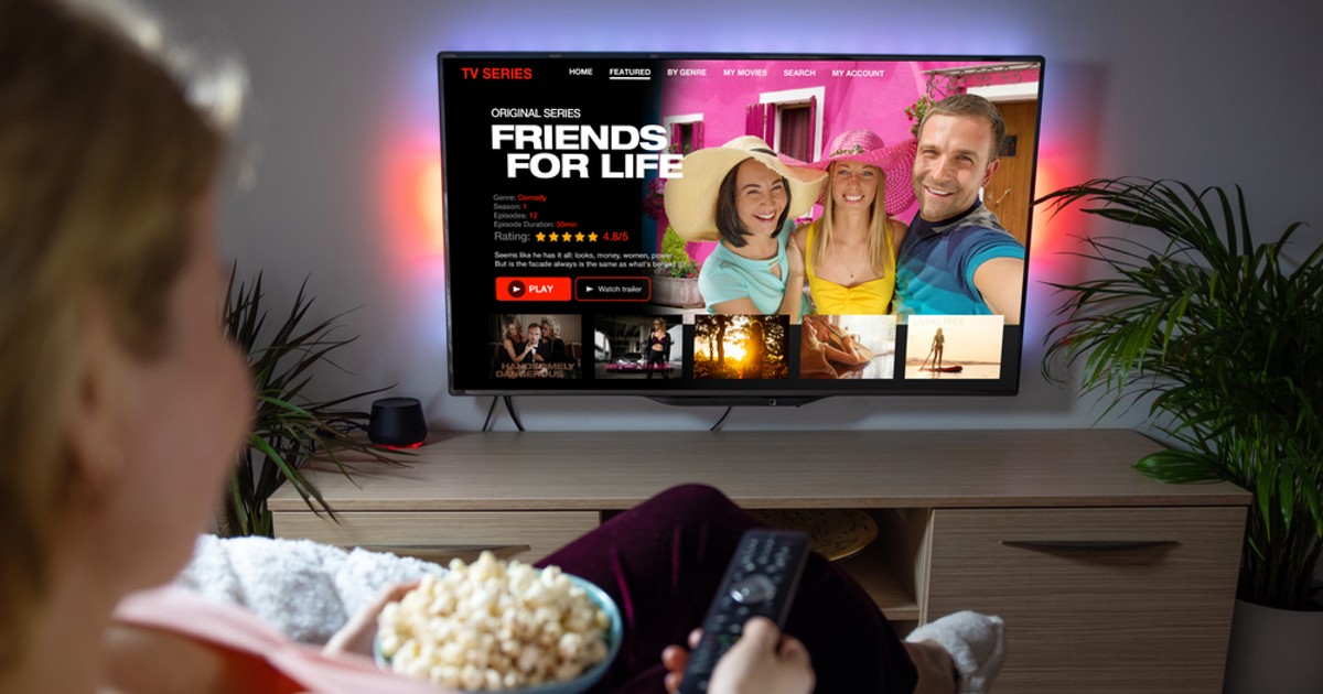 Coduri secrete Netflix. Care sunt și cum să accesezi listele cu filmele care te interesează - Imagine cu o femeie care se uită la un film pe televizor