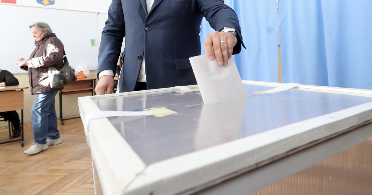 Alegător care introduce buletinul de vot în urnă