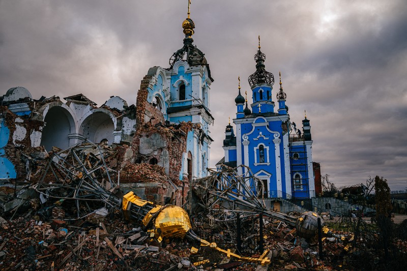 Muncitori în construcții urcă pe acoperișul unei biserici distruse în satul Bohorodychne, regiunea Donețk, pe 4 ianuarie 2023. Foto: AFP