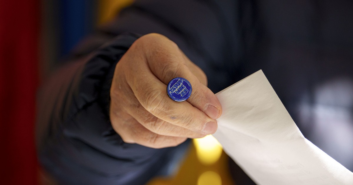 Un bărbat ține în mână o ștampilă de vot la alegerile prezidențiale