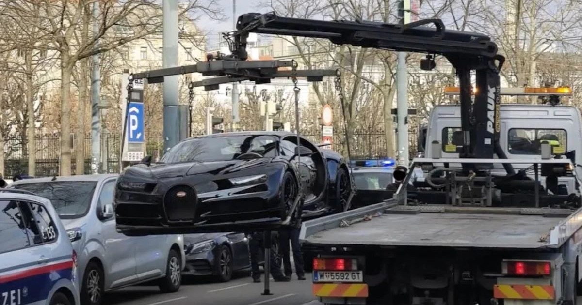 Bugatti Chiron, de culoare neagră, în timp ce este ridicat de o platformă pe o stradă din Austria