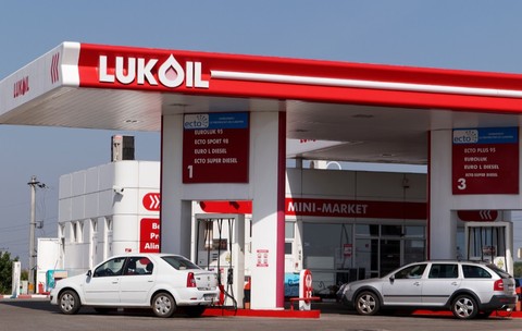O benzinărie Lukoil din România, mașinile sunt așezate la pompă și șoferii alimentează