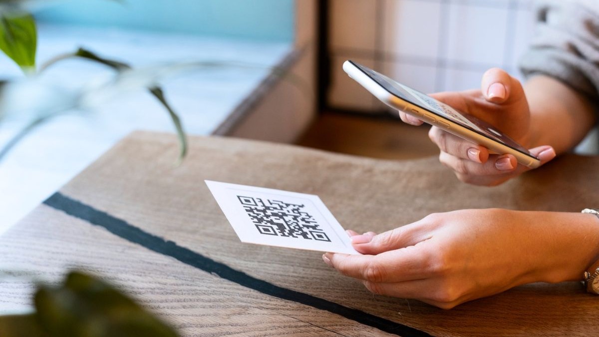 femeie care scanează un cod QR cu telefonul