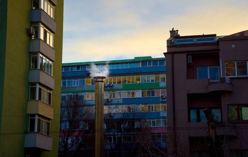 București, România 7 ianuarie 2025  Emisii de la un coș de fum înalt între blocuri de apartamente din București