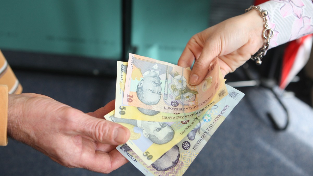 Guvernul face economie cu ”taxa pe lăcomie” chiar dacă dobânzile scad. Dou[ persoane care dau și iau bani