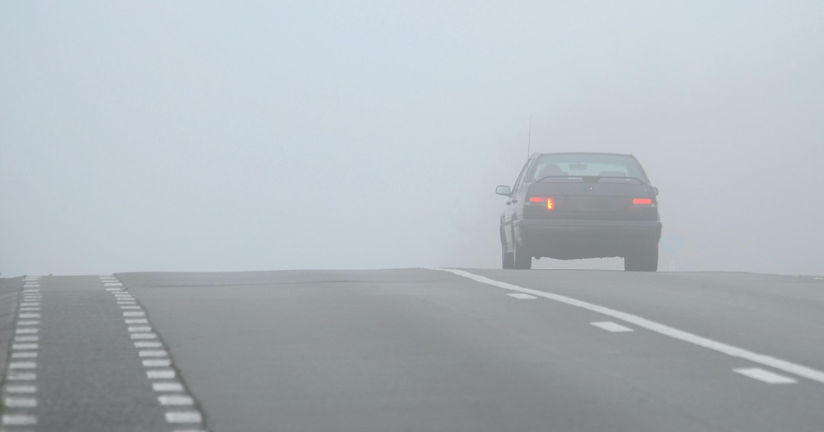 Imagine cu o mașină care circulă în condiții de ceață, pe o șosea