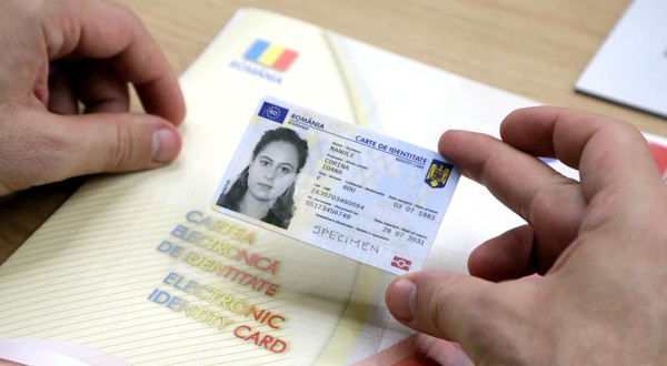Un bărbat ține în mână o carte electronică de identitate