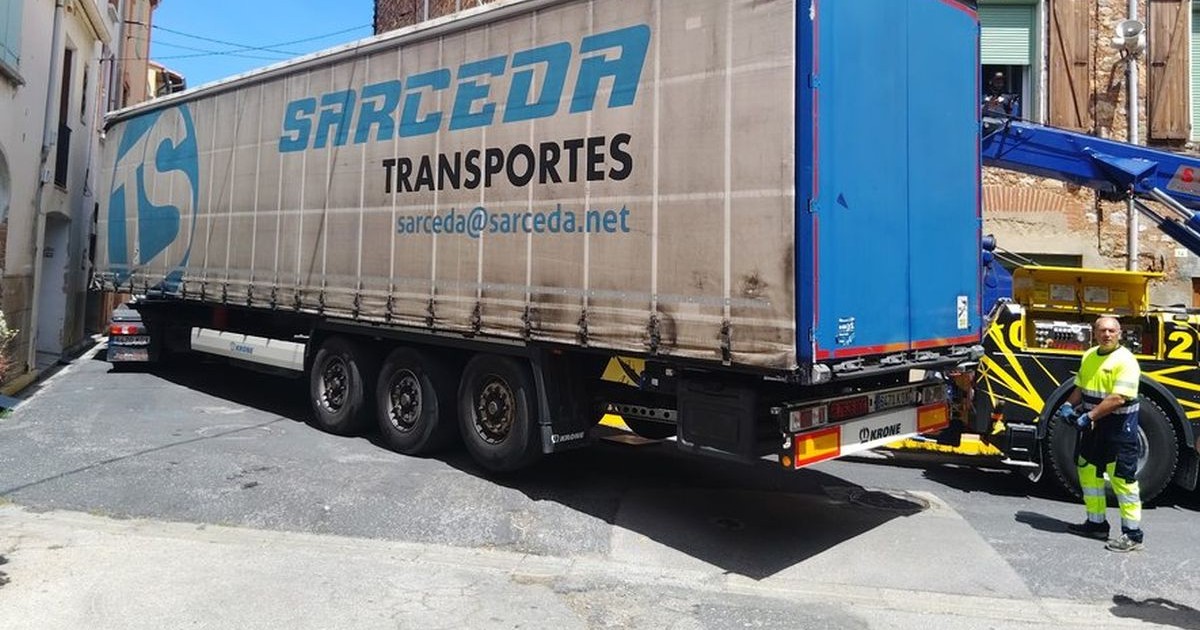 Un TIR este blocat pe o străduță, între două case, în centrul unei localități din Franța, iar șoferul a coborât ca să evalueze situația, 10 iunie 2026