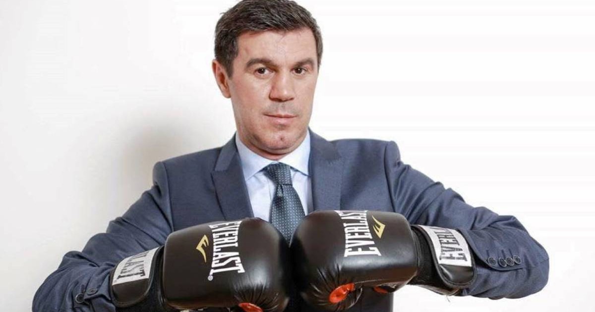 Mihai Leu îmbrăcat în costum și cu mânuși de box în mâini