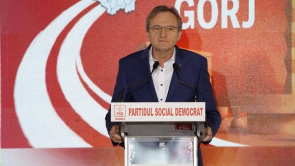 Mihai Weber în costum negru care se află la un pupitru pe care scrie Partidul Social Democrat 