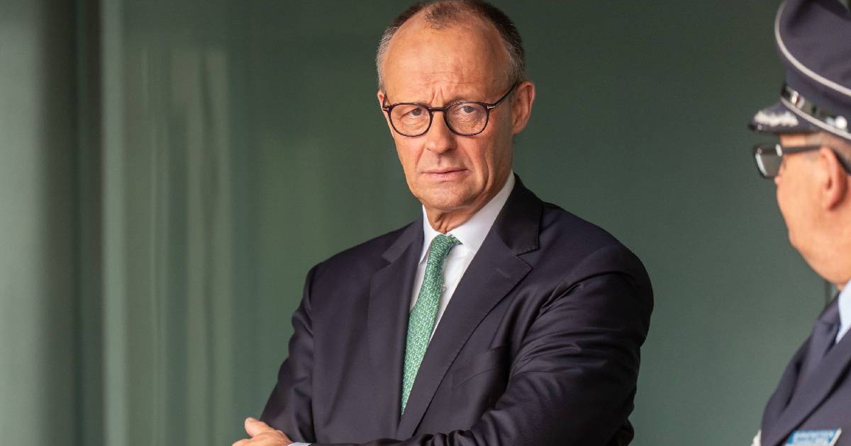 În imagine, Friedrich Merz se uită direct î camera foto. Cancelarul german poartă costum închis la culoare și o cravată verde