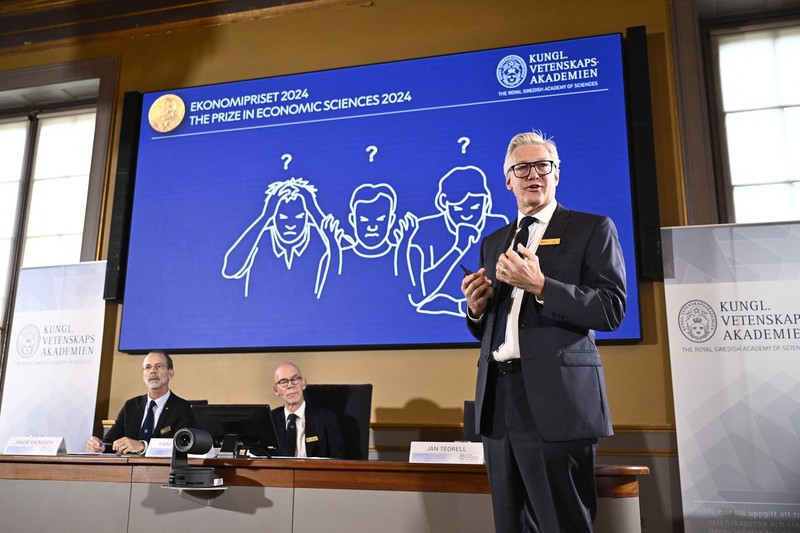 Academy of Sciences permanent secretary Jan Teorell, of the Nobel assembly delivers a press conference in front of a screen showing results of the research of laureates of the 2024 Sveriges Riksbank Prize in Economic Sciences in Memory of Alfred Nobel, Daron Acemoglu, Simon Johnson and James A Robinson during the announcement by the Royal Swedish Academy of Sciences in Stockholm, Sweden on October 14, 2024. The Nobel prize in economics was awarded on October 14, 2024, to Turkish-American Daron Acemoglu and British-Americans Simon Johnson and James Robinson for research into wealth inequality between nations. The trio was honoured "for studies of how institutions are formed and affect prosperity", the jury said.,Image: 920843537, License: Rights-managed, Restrictions: Sweden OUT, Model Release: no