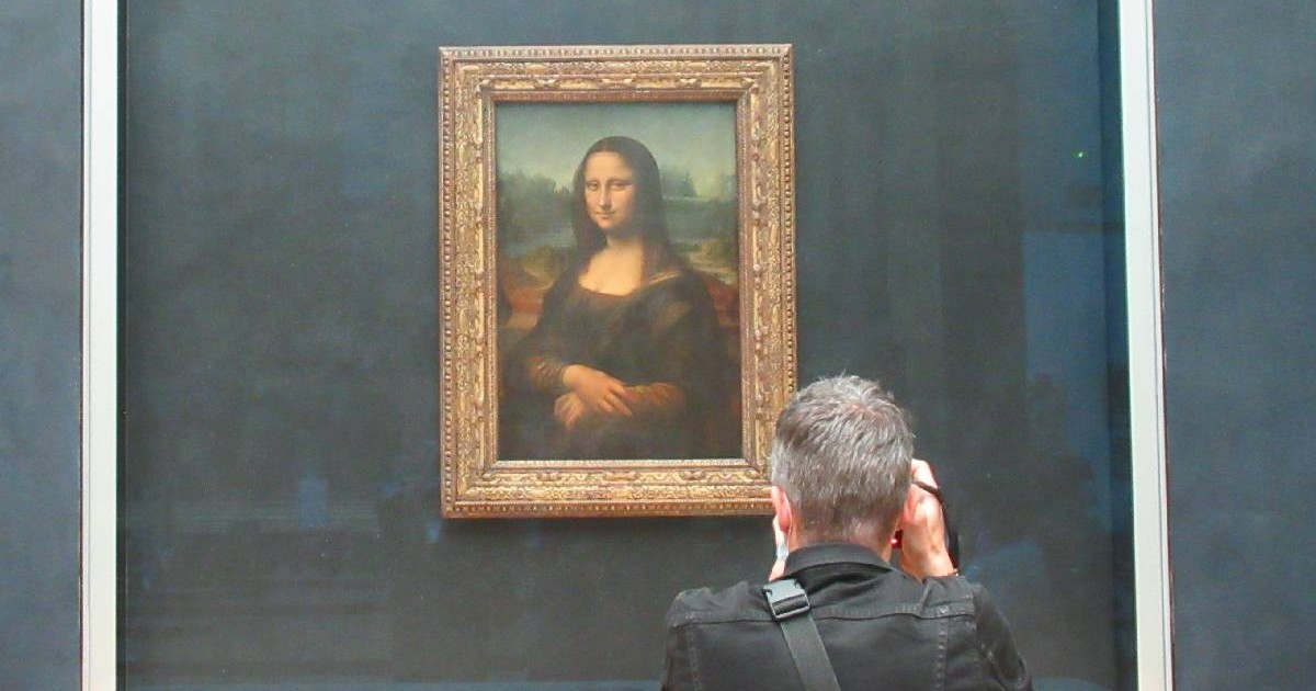 Un vizitator face o fotografie a tabloului „Mona Lisa” de Leonardo da Vinci, la muzeul Luvru.