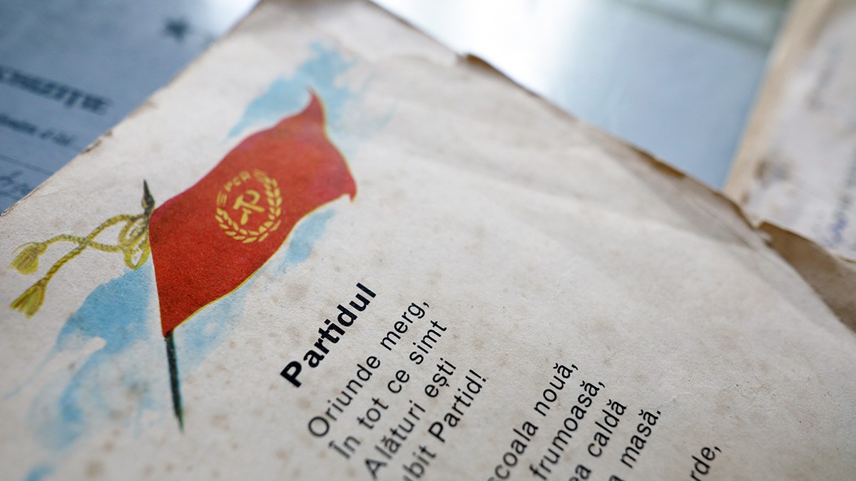 Un steag al Partidului Comunist Român și o poezie naționalistă într-un manual școlar vechi pentru copii