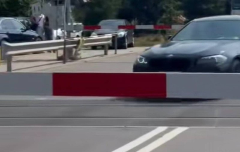 Un șofer de BMW a fost prea grăbit să aștepte să treacă trenul, așa că a ignorat complet bariera coborâtă | VIDEO