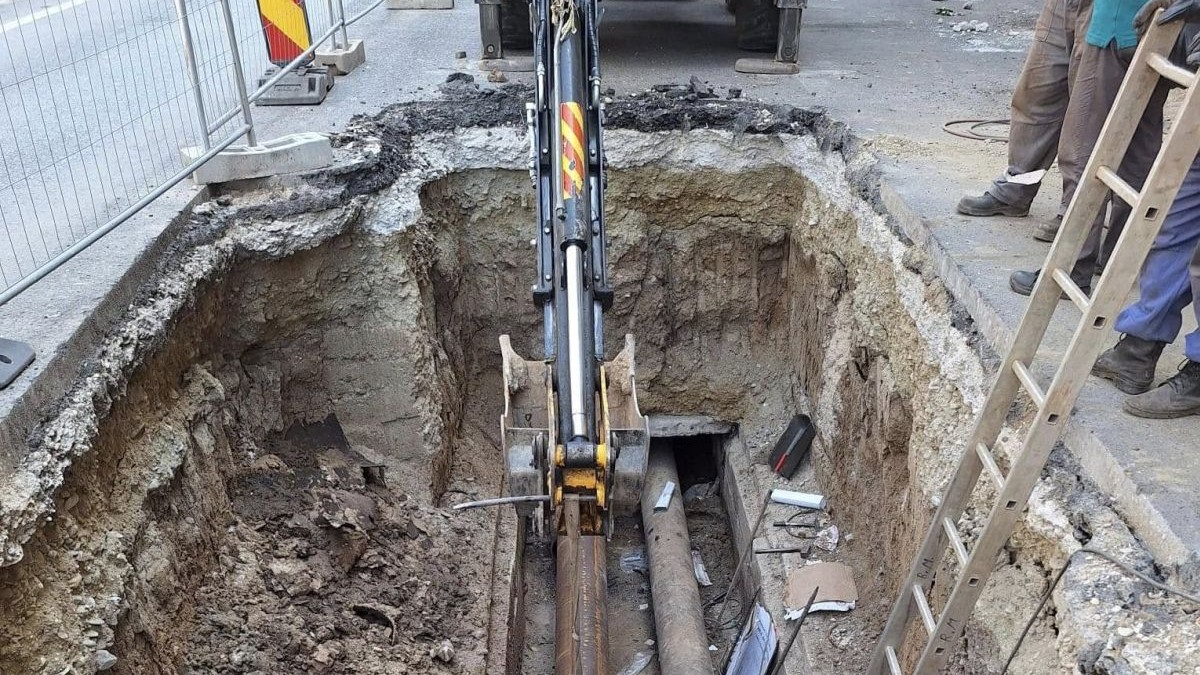 Mai mulți muncitori lucrează la schimbarea unor țevi, după ce a apărut o avarie la conductele de apă caldă