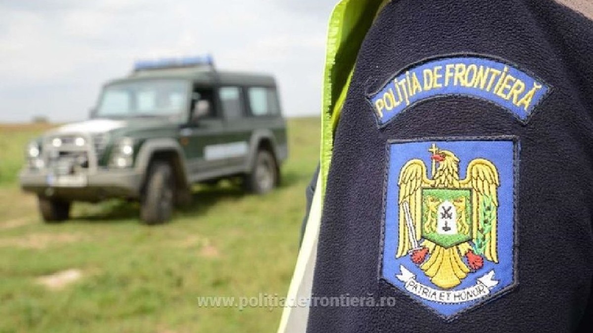 Insigna de la Poliția de Frontieră, in zare se vede o masina de la politia de frontiera