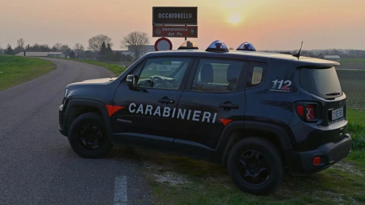 O mașină de teren a Carabinierilor italieni oprită pe marginea unui drum rural, lângă un indicator rutier pentru localitatea Occhiobello, la apus.