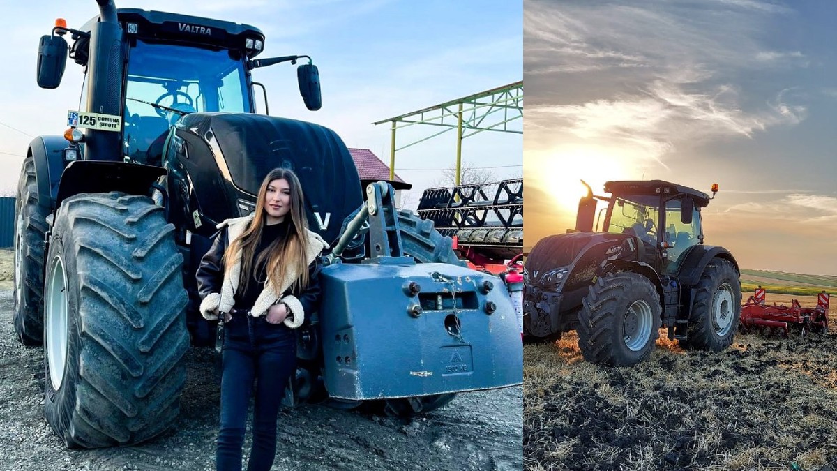 O tânără in geaca neagra de piele, căptușita cu blana, pozeaza in fata unui tractor