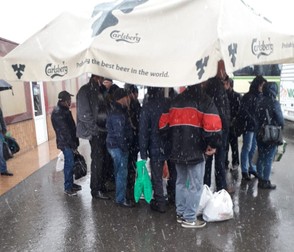 În vreme de pandemie, un grup de mineri aşteaptă autobuzul care-i duce la carieră