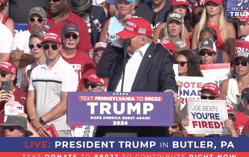 Imaginea îl prezintă pe Donald Trump vorbind la un miting electoral în Butler, Pennsylvania, în fața unei mulțimi de susținători.