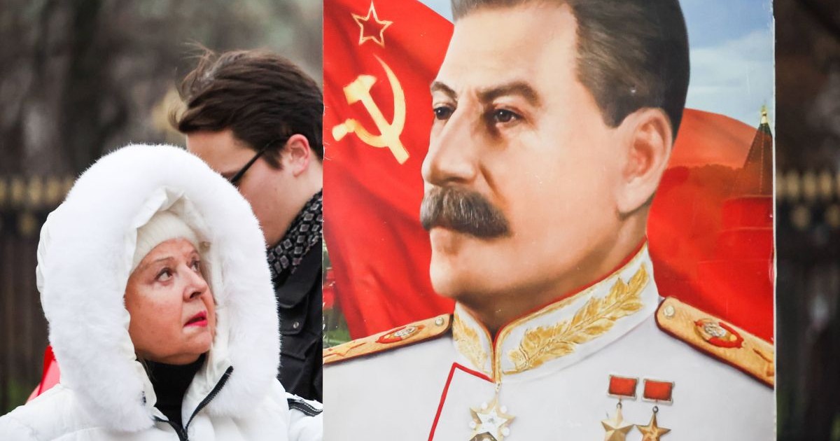 O femeie privește portretul lui Iosif Stalin înainte de o ceremonie de depunere de flori la mormântul liderului sovietic lângă Zidul Kremlinului, Moscova, Rusia, 21 decembrie 2025