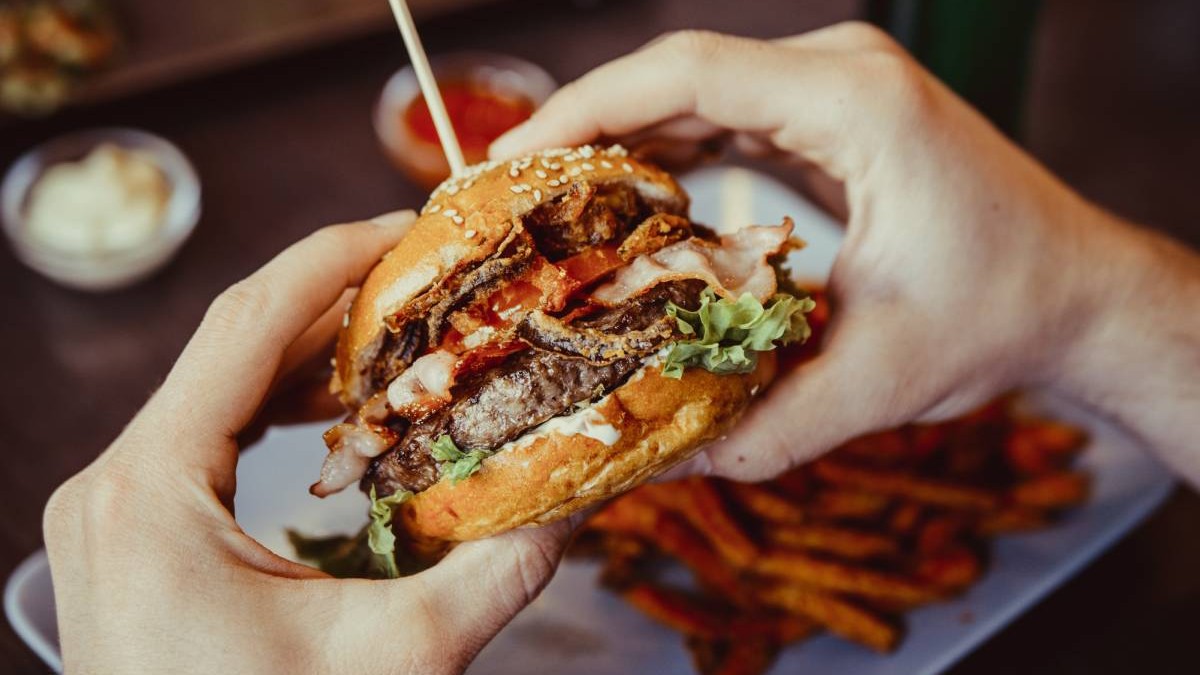 Cadru strans cu msinile unui bărbat care tin un burger