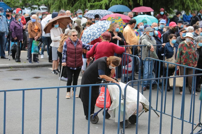 Câteva sute de persoane au format o coadă în fața Sălii Palatului, în ciuda ploii