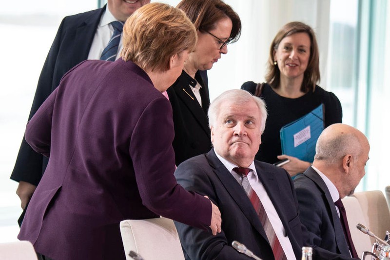 Angela Merkel i-a întins mâna ministrului de Interne, însă acesta a refuzat să i-o strângă. Foto: EPA