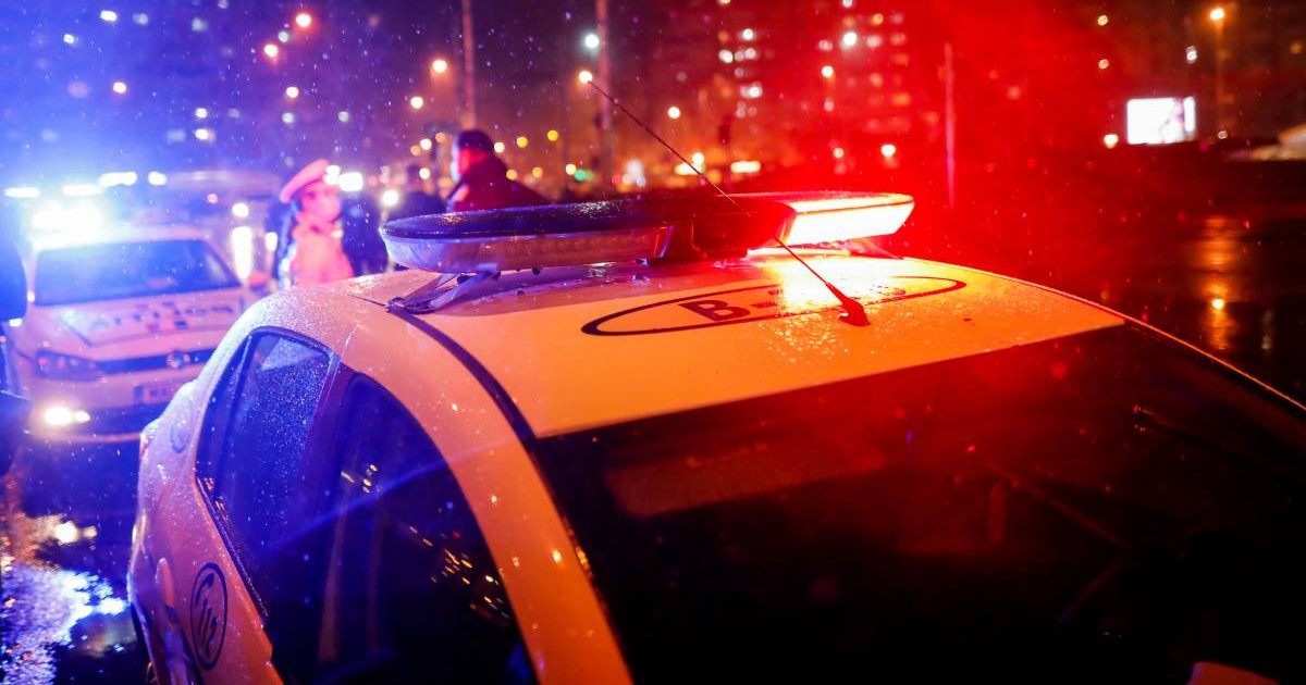 Mașina de politie cu girofaruri pornite, lumini rosii, noaptea