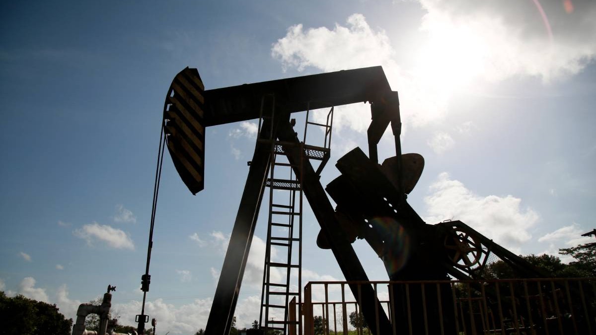 O pompă de extracție a petrolului este vizibilă la răsărit, în câmpul petrolier din Cabimas. Foto: Jose Bula.