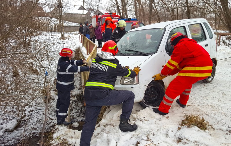 O femeie blocată într-o mașină care rămăsese suspendată pe un pod din județul Suceava a fost salvată de pompierii militari