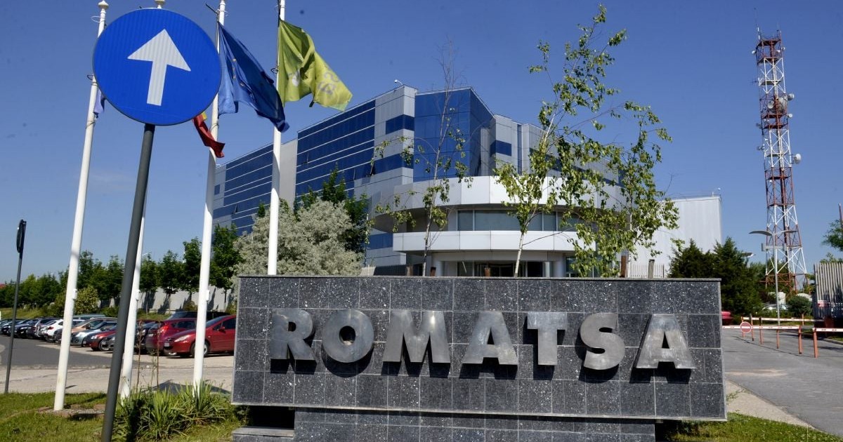 Sediul central al ROMATSA, cu o plachetă de granit de culoare gri pe care scrie ROMATSA, clădirea pe fundal și cerul albastru