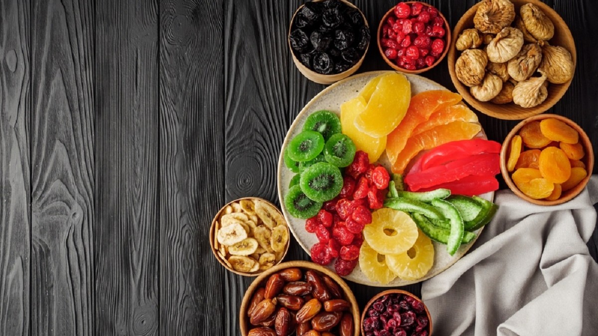 Cele mai sănătoase fructe uscate și beneficiile lor pentru organism - Imagine cu farfurii şi boluri cu fructe uscate, între care se disting, stafide, banane, caise, curmale smochine, kiwi, căpşuni şi ananas.