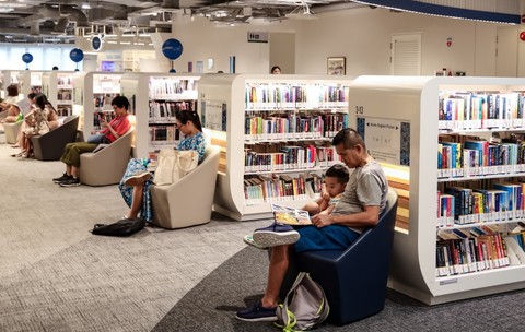 SINGAPORE – 6 OCT 2024: Un tată îi citește fiului său la Biblioteca Punggol.