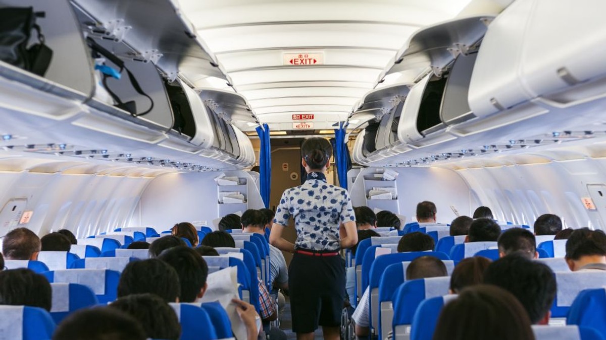 Ce se întâmplă în avion, în timpul zborului, fără să știi. Însoțitoare de zbor, cu spatele, într-un avion