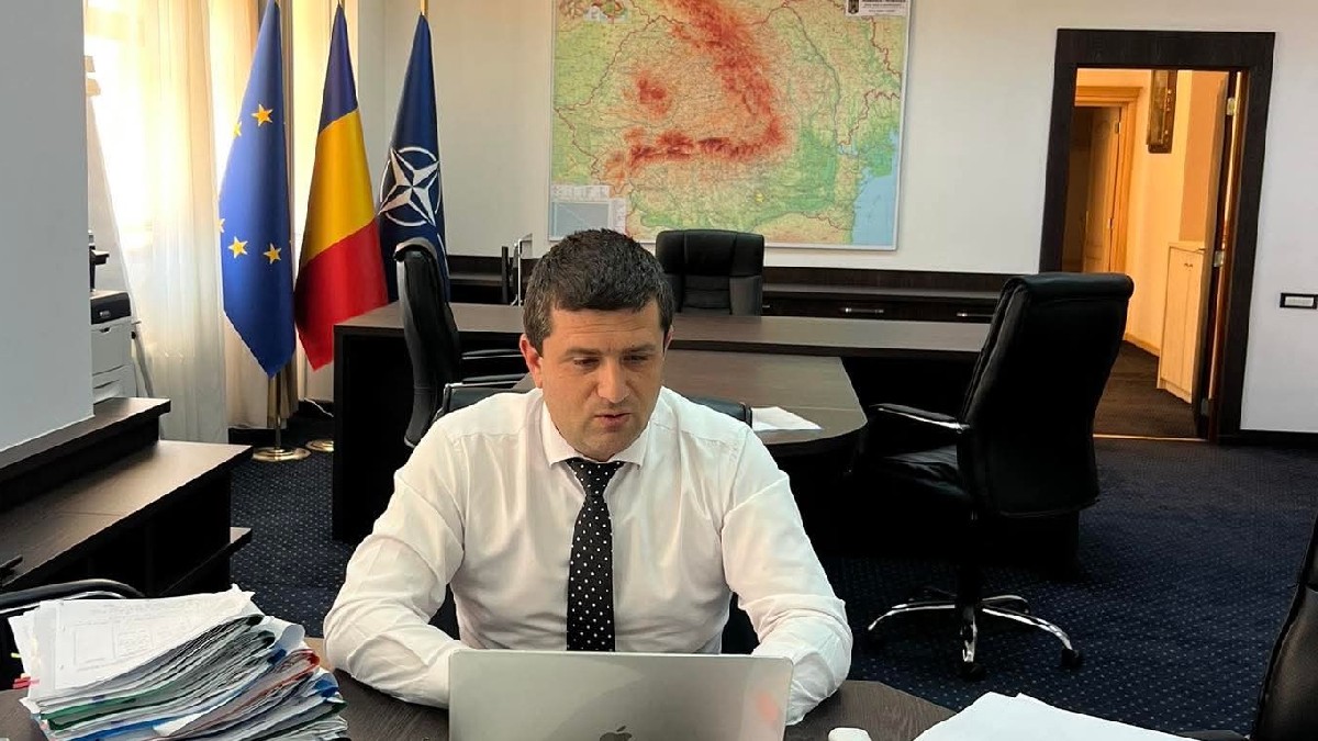 Ministrul Radu Miruță în birou în timp ce verifică ceva pe un laptop